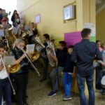 Schüler spielen Blasinstrumente und Schlagzeug im Schulflur.