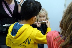 Kinder halten Instrumente und interagieren miteinander.