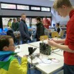 Schüler arbeiten an technischen Projekten in einem Klassenzimmer.