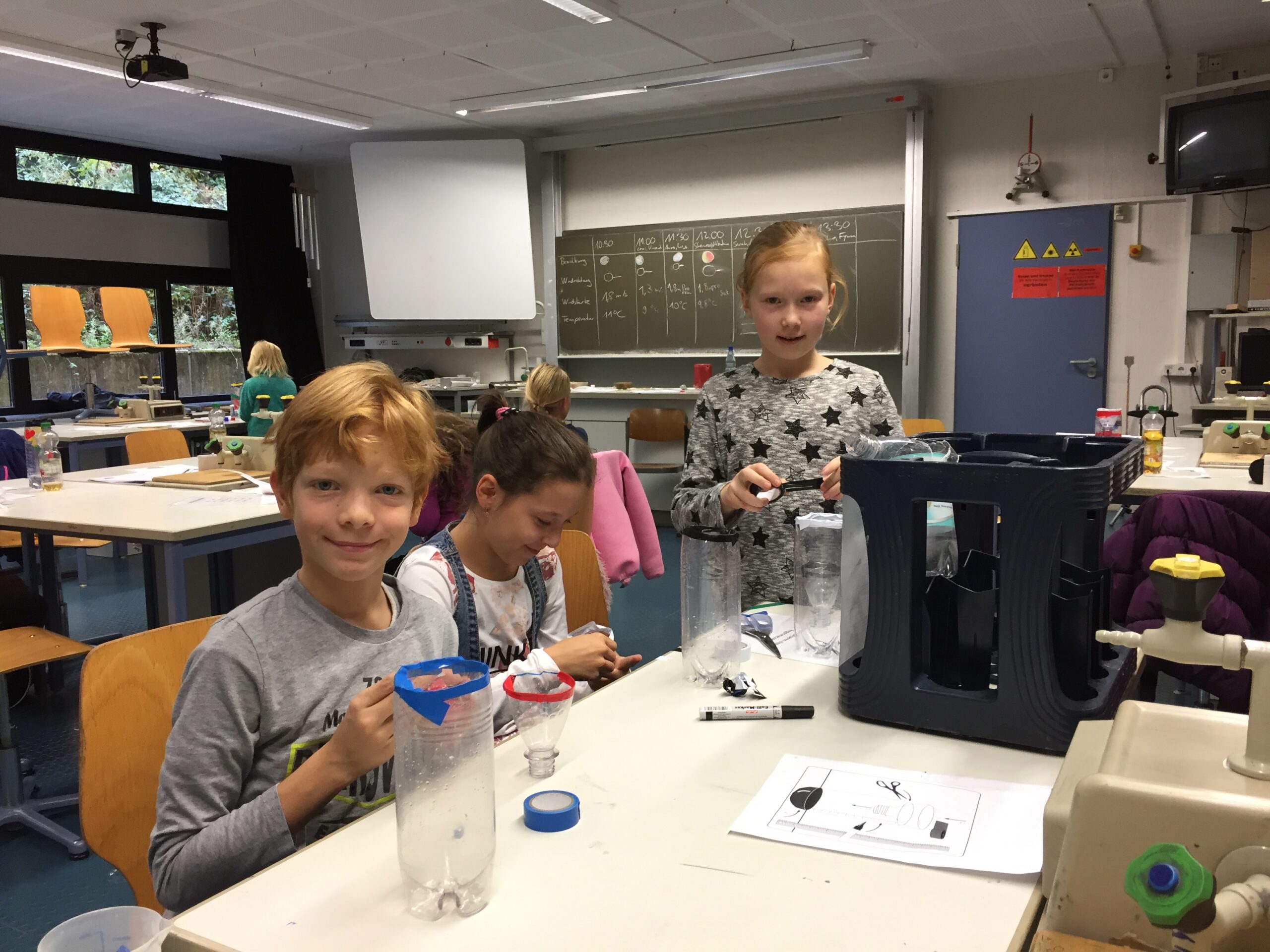 Kinder arbeiten in einem Klassenzimmer an einem Experiment.