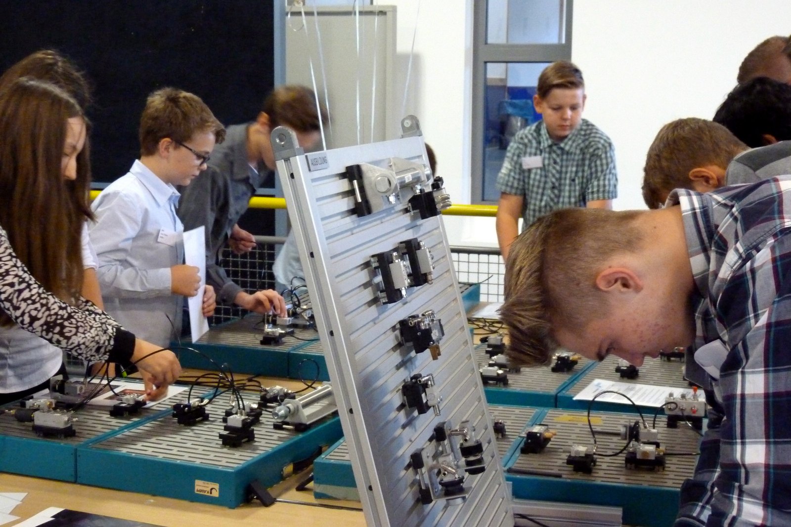 Schüler arbeiten an technischen Geräten in einem Unterrichtsraum.