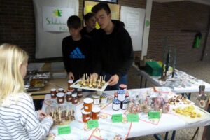 Schüler präsentieren Snacks und Selbstgemachtes auf einem Verkaufsstand.