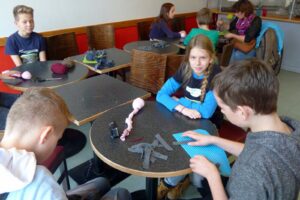 Schüler arbeiten an kreativen Projekten in einem Café.
