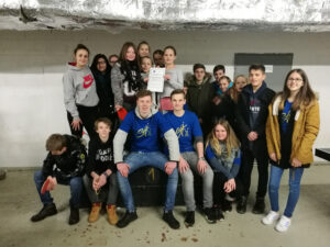 Gruppenshot von Jugendlichen mit Urkunde in einem Innenraum.