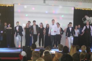 Schüler führen auf einer Bühne einen Tanz oder eine Aufführung vor.