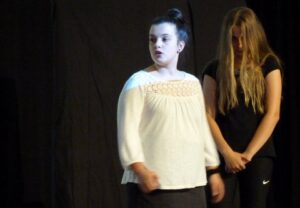 Zwei Schülerinnen auf einer Bühne während einer Aufführung.