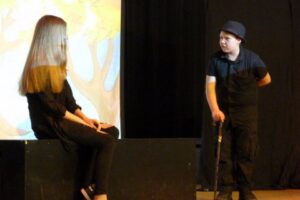 Zwei Darsteller auf der Bühne in einer Theateraufführung.