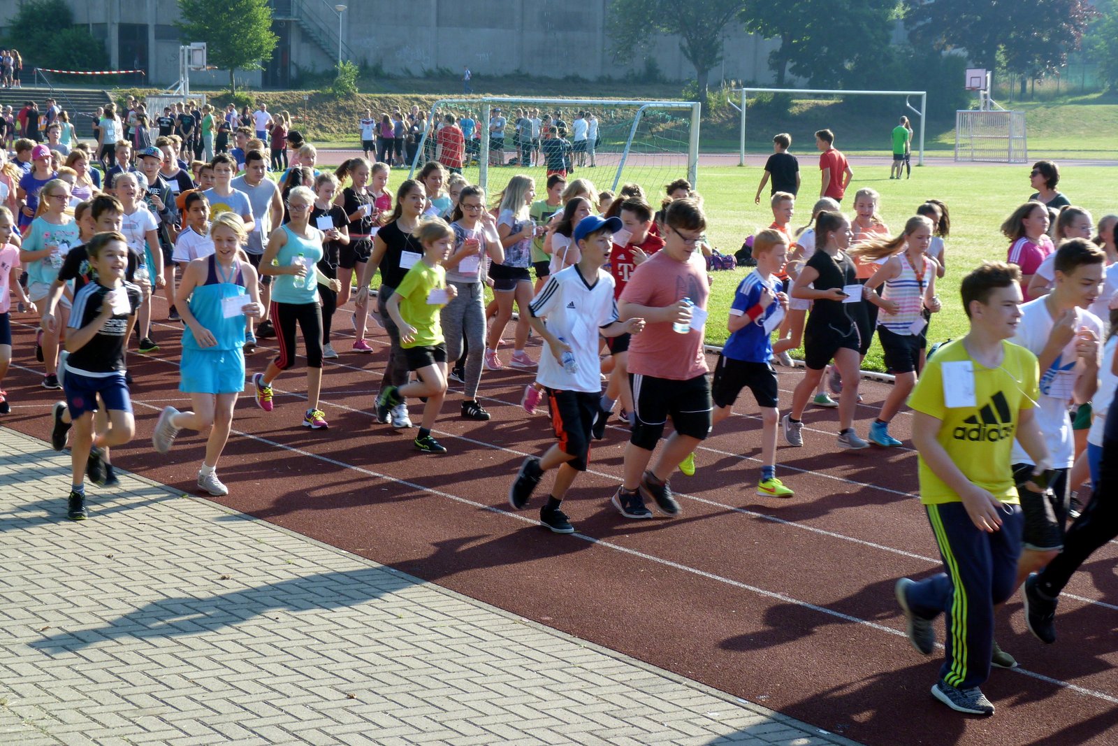 Schüler laufen auf einer Sportbahn während eines Wettkampfs.