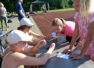 Sportliche Aktivitäten mit Kindern und Jugendlichen an einem Tisch im Freien.