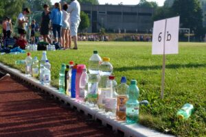 Leere Plastikflaschen stehen an der Seitenlinie eines Sportplatzes.
