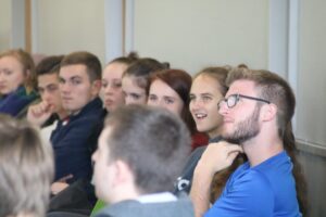 Gruppe von Schülern, die aufmerksam einer Präsentation lauschen.