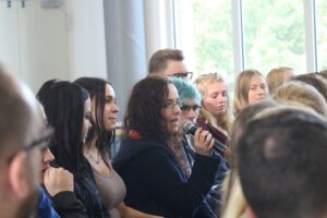 Eine Schulveranstaltung mit einer Gruppe von Schülern, die aufmerksam zuhören.