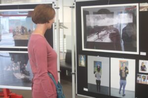 Besucherin betrachtet Fotos in einer Ausstellung.