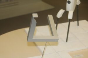 Graues, geometrisches Objekt auf einer Ausstellungstreppe.