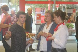 Drei Personen stehen in einer modernen Umgebung und unterhalten sich.