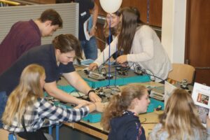 Schüler arbeiten gemeinsam an technischen Geräten und Projekten.