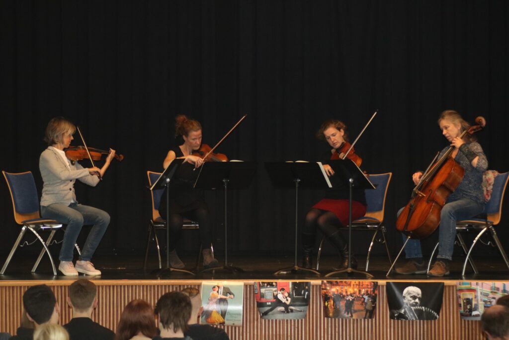Vier Musikerinnen spielen auf der Bühne Geigen und ein Cello.
