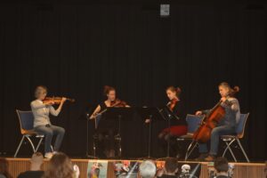 Vier Musikerinnen spielen ein Streichquartett auf einer Bühne.
