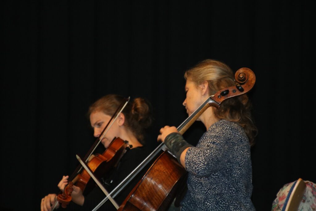 Zwei Musikerinnen spielen Geige und Cello auf einer Bühne.