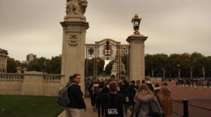 Besucher gehen durch das Tor zum Buckingham Palace.