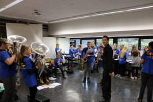 Schüler*innen einer Musikgruppe proben in einem Raum mit Instrumenten.