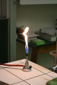 Bunsenbrenner mit blauer Flamme in einem Labor.