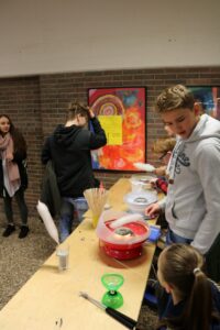 Schülerinnen und Schüler arbeiten an einem Basteltisch in einem Klassenzimmer.