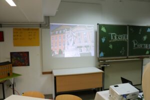 Ein Klassenzimmer mit einem Projektor, der ein Bild an die Wand projiziert.