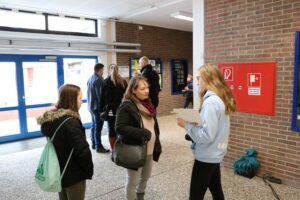 Schüler und Erwachsene im Schülerzentrum, Gespräche im Eingangsbereich.