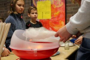 Schülerinnen und Schüler beobachten bei einer Zuckerwatte-Demonstration.