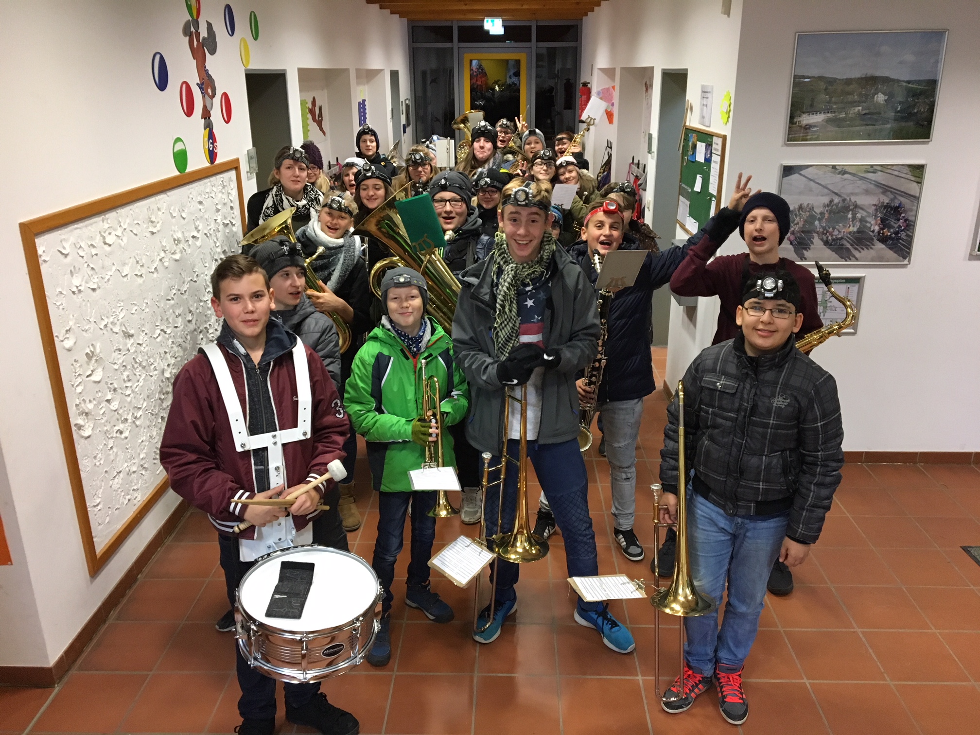 Schüler mit Musikinstrumenten in einem Flur der Schule, Gruppenfoto.