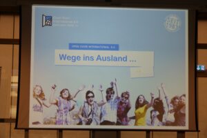 Präsentation über Auslandsmöglichkeiten mit feiernden jungen Menschen.