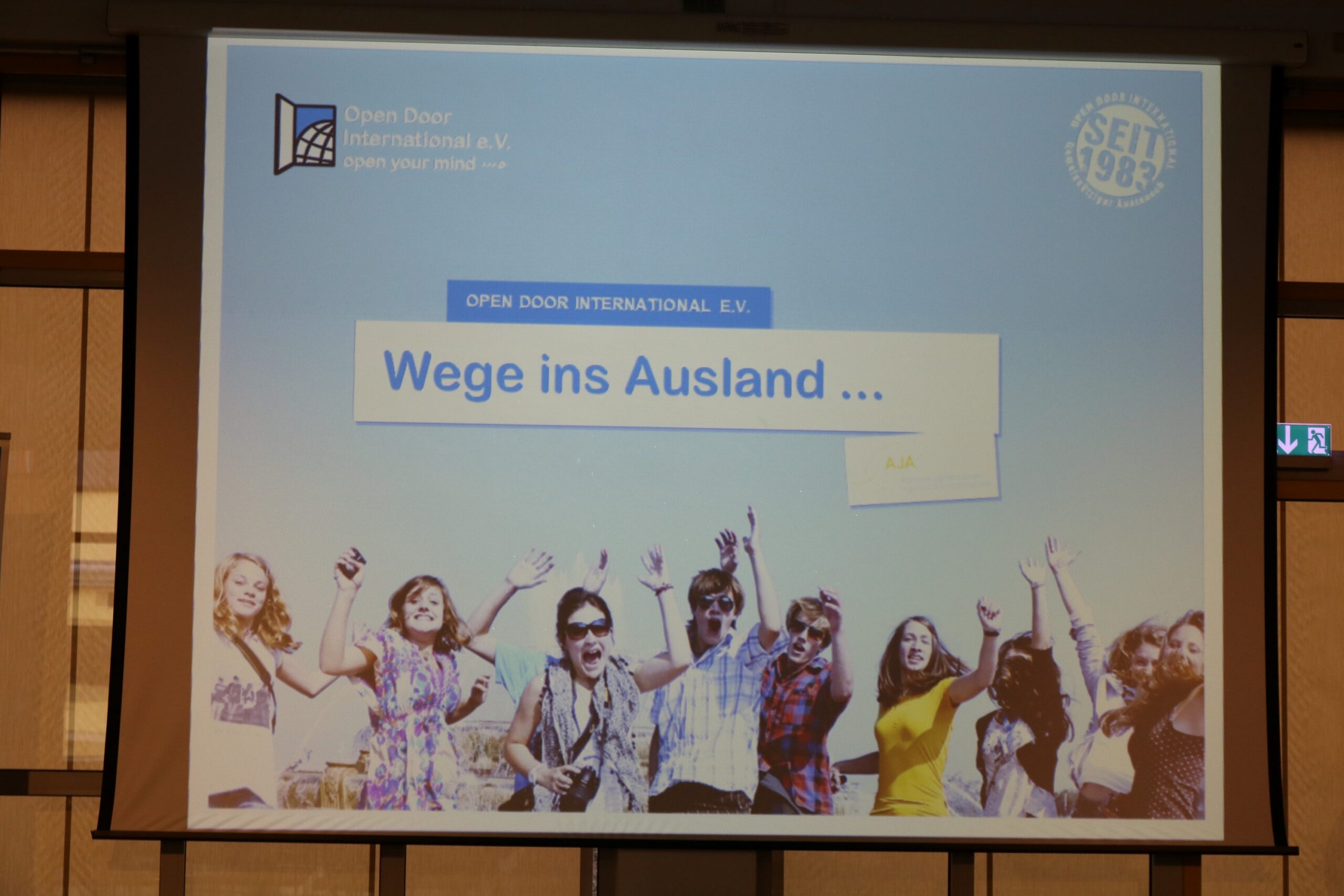 Präsentation über Auslandsmöglichkeiten mit feiernden jungen Menschen.