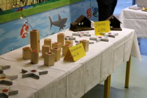 Tisch mit Holz- und Betonobjekten sowie Preisschildern.