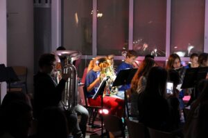 Schüler musizieren mit Blasinstrumenten auf der Bühne bei einem Konzert.