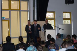 Veranstaltung im Schulraum mit Rednern vor Publikum.