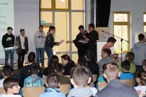 Schüler nehmen an einer Preisverleihung auf der Bühne teil.