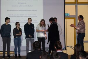 Verleihung von Preisen an Schüler während einer Veranstaltung.