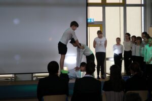Schüler führen eine Gymnastik- oder Tanzaufführung auf einer Bühne vor.