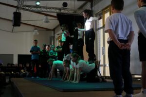 Schüler führen eine Akrobatik-Performance in der Turnhalle auf.