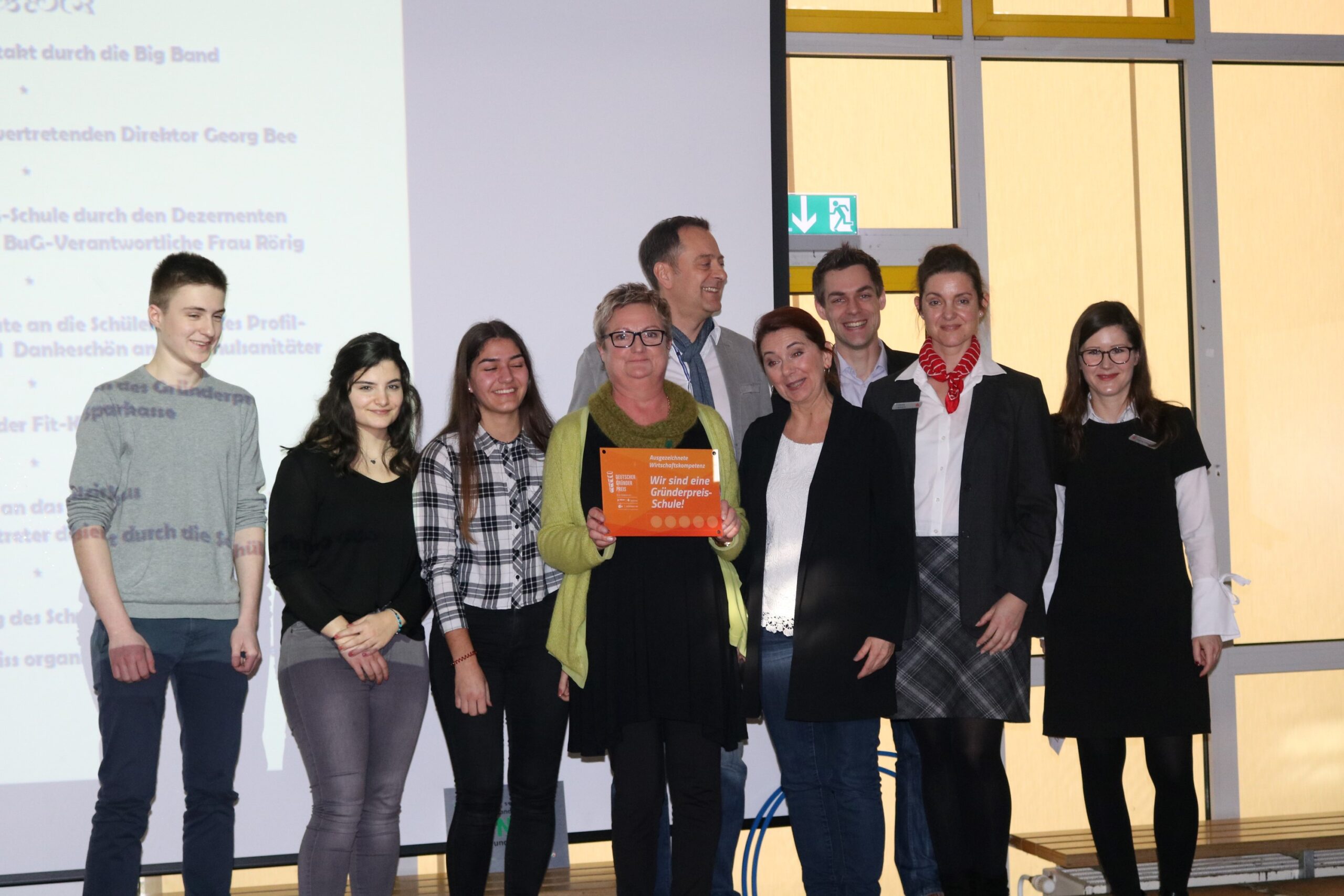 Gruppe von Personen bei einer Präsentation, einige halten eine Auszeichnung.