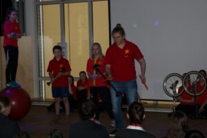 Schüler führen eine Präsentation mit verschiedenen Darbietungen auf einer Bühne vor.