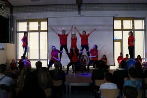 Schüler führen eine Tanz- und Akrobatikaufführung auf einer Bühne vor.