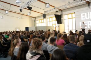 Vielzahl von Schülern in einem großen Raum bei einer Veranstaltung.