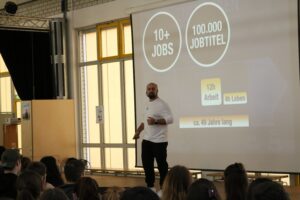 Mann spricht vor Schülern, Präsentation über Jobs und Lebenswege.