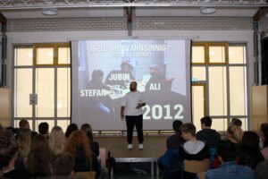 Vortrag mit Publikum, Projektor zeigt Präsentation über 2012.