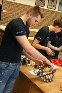 Schüler arbeitet an einem Robotik-Projekt am Tisch.