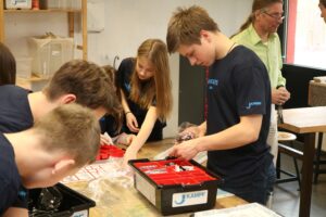 Schüler arbeiten an Projekten mit Werkzeugen in einem Klassenzimmer.
