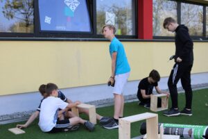 Schüler bauen Holzprojekte draußen auf dem Schulgelände.