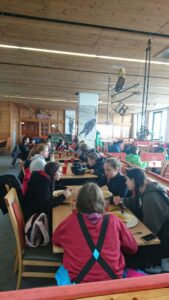 Schülerinnen und Schüler essen in einer großen Kantine.